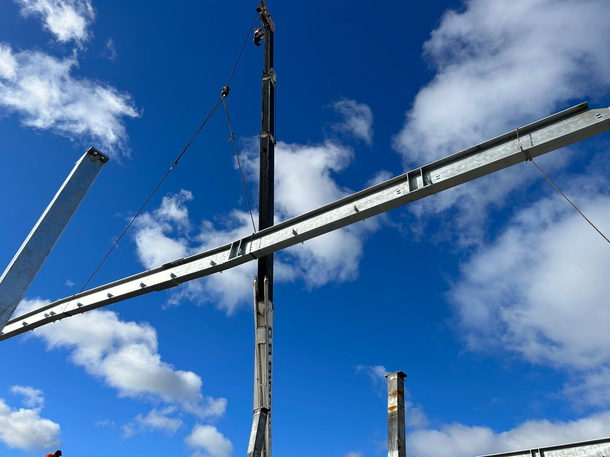 Steel construction site with workers fabricating structural beams